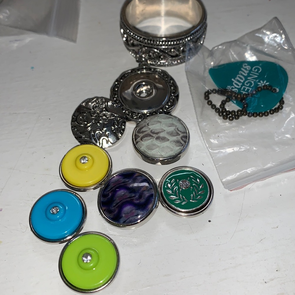 One silver tone scarf ring with 7 changeable snaps.  NWOT